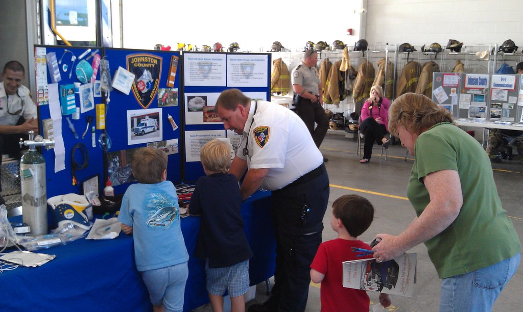 Kids being taught at a station in front of a JCEMS Trifold